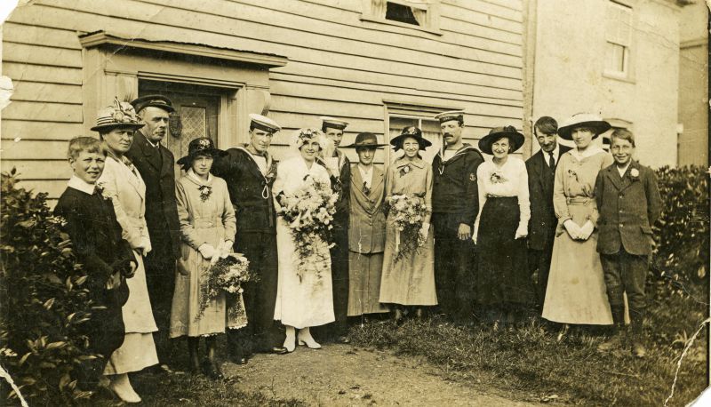  Photograph was taken outside Moss Cottage, Queens Corner after the marriage of Lucy Sarah Hoy and Archibald Percy Green on 29 September 1917 at St. Peter and St. Paul Church. The rector of East Mersea, the Rev. Ronald Dunn, took the service. The bridegroom was an AB in the Royal Navy.

L-R 1. Horace Green (Ock's son) 2. Maud Mussett (Mrs Whitey) 3. Oscar 'Ock' Green - groom's father 4. Ella ...
Cat1 Mersea-->Buildings Cat2 Families-->Green Cat3 Museum-->DisplayPhotos Cat4 War-->World War 1