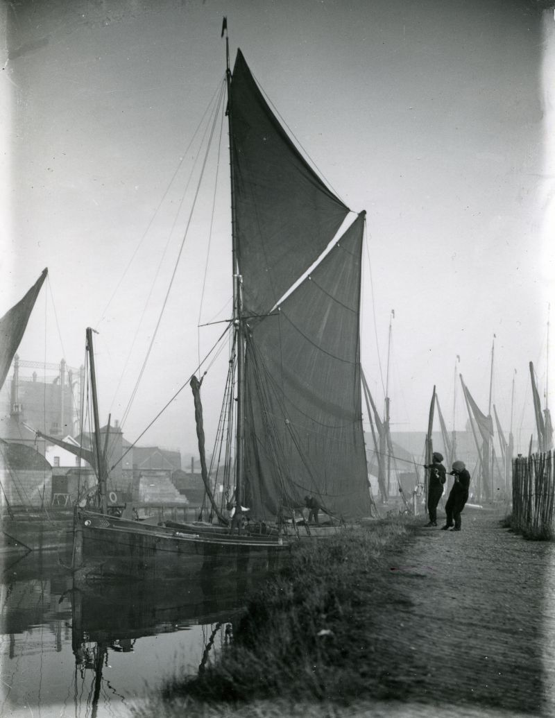  Barge DAWN at Colchester Hythe c1901. Charles and Daniel Hales, the local hufflers, are walking and hauling on a light line made fast to the mast.

Used in John Leather's Barges, page 75. 
Cat1 Barges-->Pictures Cat2 Places-->Colchester-->Hythe