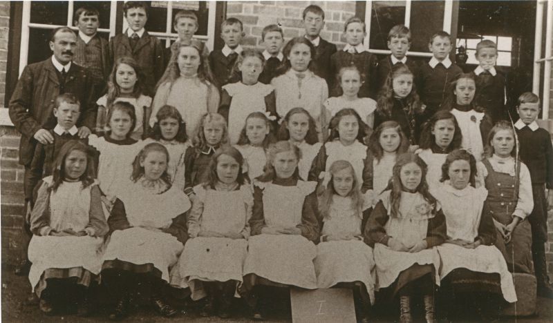  Birch School group I. 1890s. Headmaster Mr Chandler on the left.

Back row L-R 1., 2. Charlie Everitt, 3., 4., 5., 6., 7., 8., 9., 10.

Second from back 1. Mr Chandler, headmaster, 2. Eva Partner, 3. Ida Bond, 4., 5. Beatrice Tosbel [born 1899], 6. Lily Pentney, 7. Ida Polly, 8. Eva French, 9.

Third from back 1., 2., 3. Maud Fisher, 4. Violet Pepper, 5., 6. Nora Tosbel, 7. Meg ...
Cat1 Birch-->School