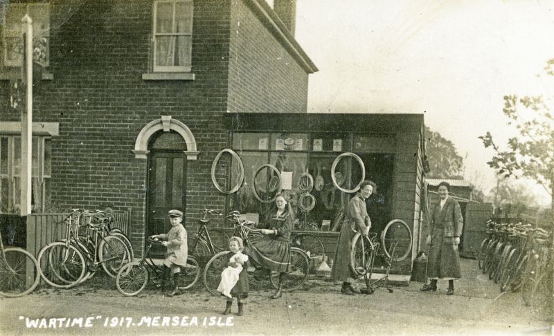 Click to Pause Slide Show


 Wartime 1917 Mersea Isle. Snuffy Cornelius's cycle shop on Kingsland Road, now RST Motors.

Frank Cornelius, Mabel Tiffin (lived over the road in what in 1984 was the paper shop), Mrs Arthur [ Hannah Eliza née Hyam ] Cornelius, Vera Cornelius, Elsie Cornelius.

By 1917 Arthur Cornelius was in the Army and the women were left running the business.

From Album 2. 
Cat1 War-->World War 1 Cat2 Families-->Cornelius