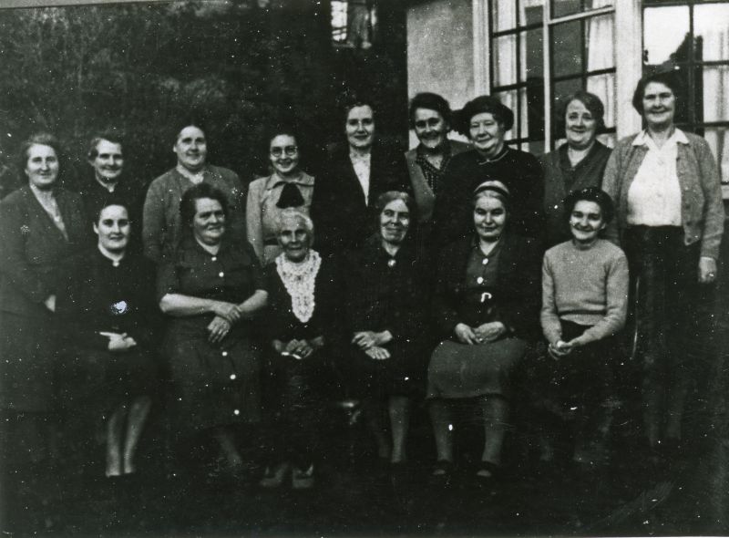  Photograph taken to celebrate the 100th Birthday of Mrs Hewes.

Back Row 1. Clara Ward ( Chatters ), 2. Mrs Green, 3. Irene Gant ( Woods ), 4. Sheila Chatters, 5. Hilda Cudmore ( Pawsey ), 6. Mrs Keene, 7. Maud Hewes, 8. Mrs Len Stoker, 9. Mrs Tite Mussett.

Front 1. Winnie Woods, 2. Violet Chatters, 3. Mrs Hewes, 4. Mrs Stoker, 5. Mrs Brewington, 6. Mrs Jack Chatters.

From Album 6. 
Cat1 Families-->Hewes