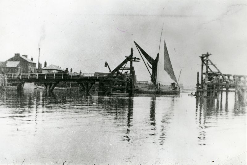  Sailing barge prepares to drop down through the opening in the Army bridge across the Colne connecting Rowhedge with Wivenhoe. This was built by the Royal Engineers during the 1914-18 war but was demolished soon after. Barges then wore red ensigns for identification by patrol vessels.

Used in Saltwater Village page 128 - source of image not recorded.

Used in Rowhedge Recollections, ...
Cat1 [Not Set] Cat2 Places-->Rowhedge Cat3 Places-->Wivenhoe-->Town Cat4 Barges-->Pictures
