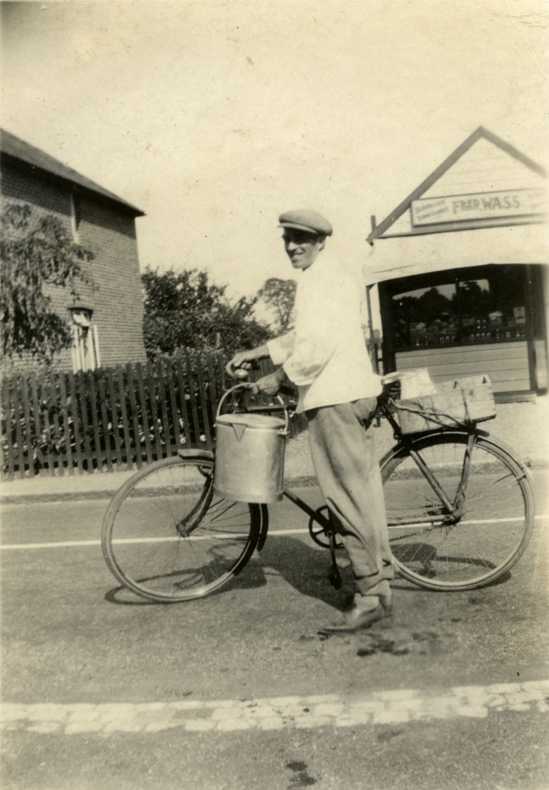 Dad 1932. [Edwin John Dixon]. Milk pail on handlebars, outside Fred Wass barbers in background.

From Dixon family photographs. 
Cat1 People-->Other