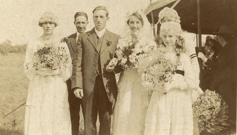  Wedding of Stanley Alfred French, a mariner of Daisy Bank, Firs Chase, and Ethel May Brown, on 20 July 1920. After their marriage at St. Peter and St. Paul Church they posed for photographs which show off the beautiful bouquets carried by the bride and bridesmaids.

Full right Ena French.

Ethel's sister Mabel was married in 1909 and is shown in DIS2009_MAR_004. 
Cat1 Museum-->DisplayPhotos Cat2 Families-->French