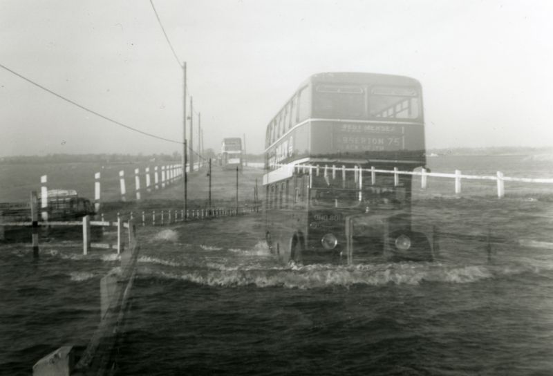  Ghosts at Mersea Strood. Most of the tales of ghosts are of Roman Centurions crossing the Strood. Did they travel by Eastern National bus, or is this just a double exposure?

The bus coming towards Mersea is Easter National ONO80, driven by A. Baveystock. Service 75 West Mersea via Abberton and Blackheath. 
Cat1 Mersea-->Strood Cat2 Smacks and Bawleys