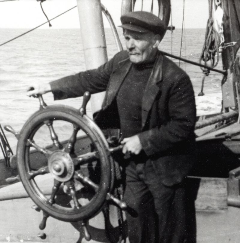  Billy Austin for many years into the 1950s skipper of the READY (MIROSA) at the wheel. A most capable bargeman.

Photo by Arthur Bennett.

Used in The Salty Shore page 188 
Cat1 [Not Set] Cat2 Barges-->Pictures