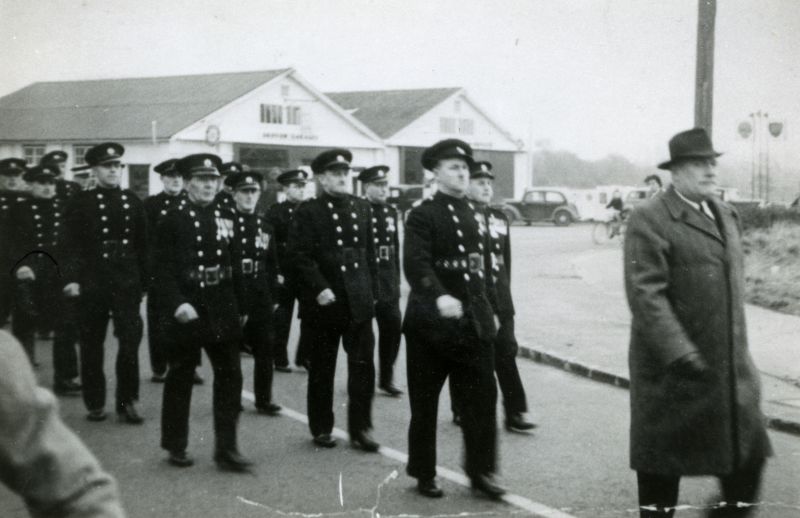 West Mersea Firemen marching in Armistice Day Parade, outside the Griffon Garage.

Roughly L-R 'Ike' Ivan King, Les Phillips, Len Coles, Horace Whiting, Bill Rayner, Bob Atkins, Bob Russell, Oscar Whiting, Frank Hodgkinson.

From Album 4. 
Cat1 Mersea-->Fire Brigade Cat2 Mersea-->Events