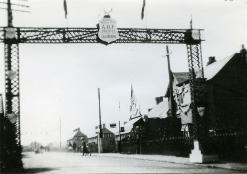  1935 Jubilee Arch in Barfield Road. AOF Salutes the Sailor King. Chemist's shop on the right.

From Album 9. 
Cat1 Mersea-->Road Scenes Cat2 Mersea-->Events
