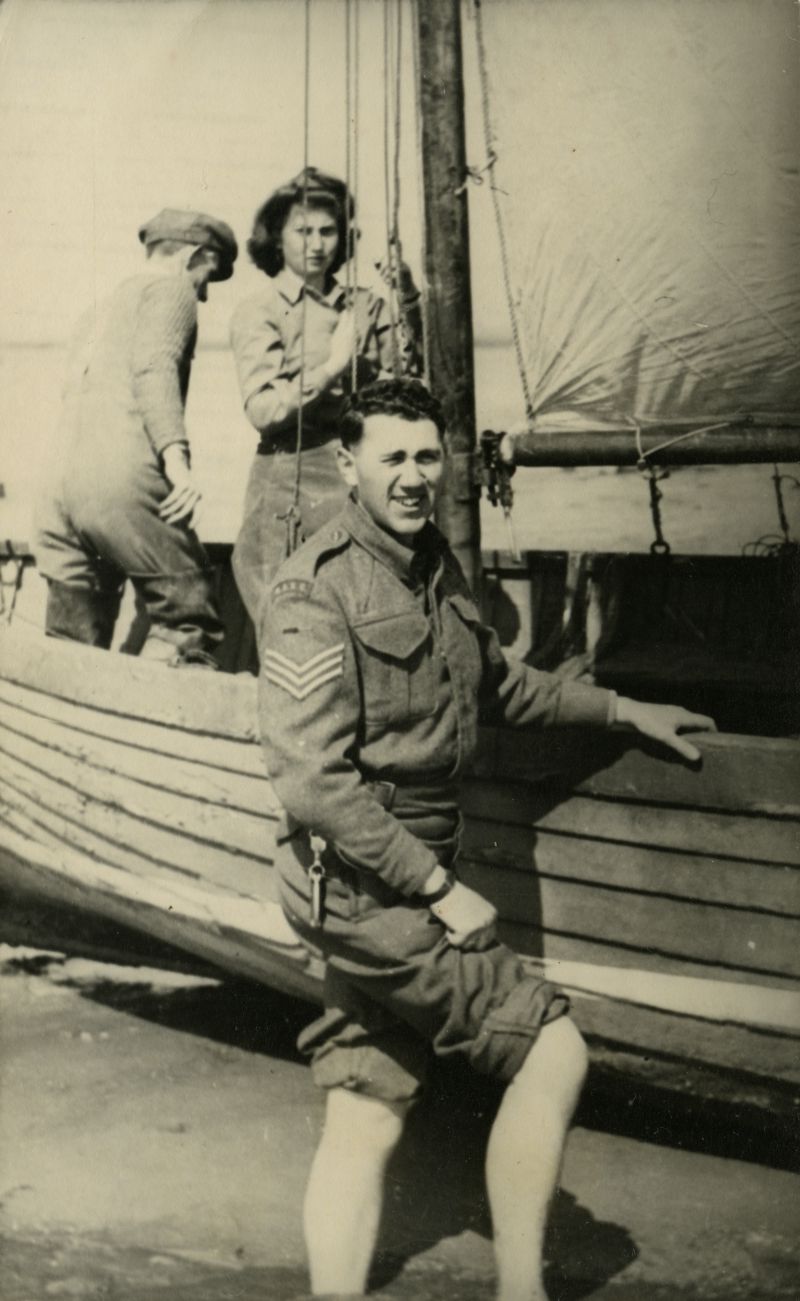  Joan Pullen by mast, Sergeant in Royal Army Service Corps in foreground. 
Cat1 Families-->Pullen Cat2 Yachts and yachting-->Sail-->Small yachts / dinghies