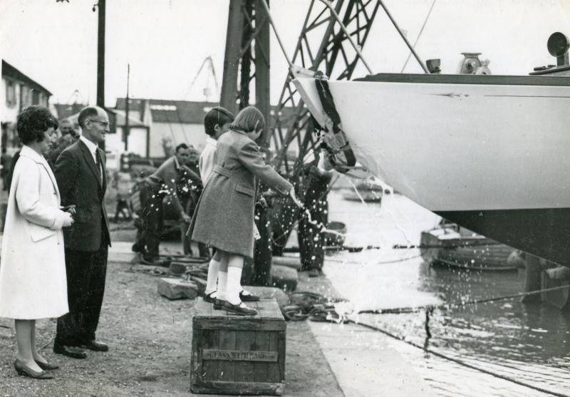  Launch of yacht JANMER, built for Norman Ward at Colne Marine [Guy Harding], Wivenhoe. Breaking the champagne - Joan, Norman and Ann Ward. 
Cat1 Yachts and yachting-->Sail-->Larger Cat2 Places-->Wivenhoe-->Shipyards Cat3 Families-->Pullen