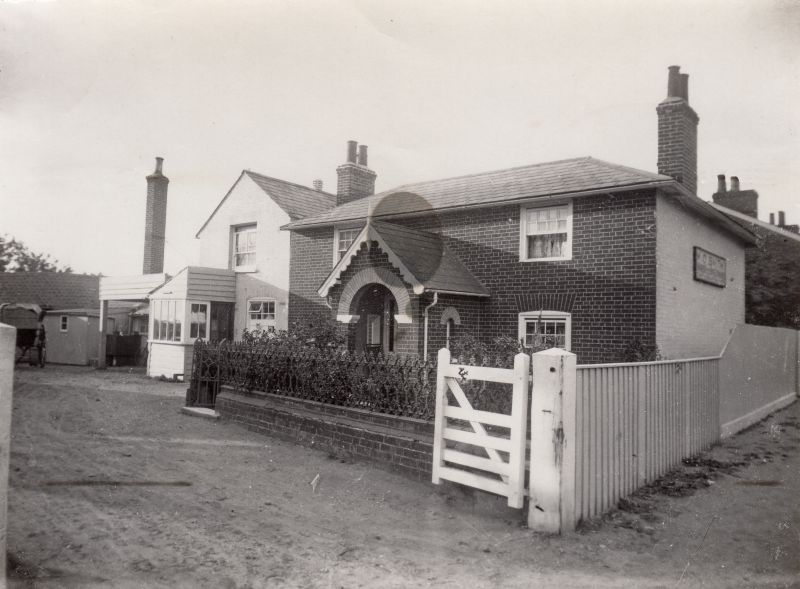  West Mersea mill. The Bakery chimney is on the left, the Mill shop with its sloping roof in front of the white office (ground floor) and nursery (top floor). Mill House is on the right. The sign still says M.O. Smith, dating this view to 1902 - 1920. 
Cat1 Mersea-->Shops & Businesses Cat2 Mersea-->Buildings