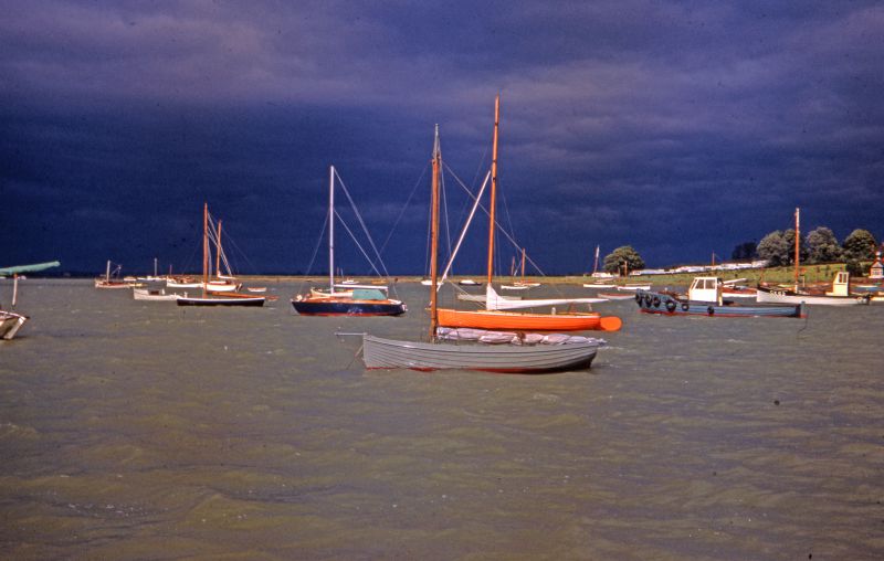  Looking northeast up the Strood Channel. Simmonds' caravan park on right and Nothe Cottage just visible. CK62 EVELYN owned by Hector Stoker. 
35mm slide by Jean Booth. 
Cat1 Mersea-->Old City & the Hard Cat2 Smacks and Bawleys