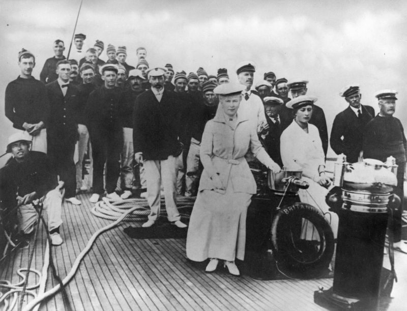  H.M. Yacht BRITANNIA. 

H.M. King Georve V, H.M. Queen Mary, H.R.H. Prince Albert(Duke of York), H.R.H. Princess Mary.

Major Philip Hunloke, Helmsman, Captain Charles Leavett, Sailing Master.

A large photograph, copied from one taken by Captain Sydney C. Leavett. 
Cat1 Yachts and yachting-->Sail-->Larger Cat2 People-->Other