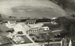  Birch School - an aerial view in the late 1950s, source unknown. The new staff room and toilet block are visible, built in 1957. The top of the church spire can just be seen lower right.
</p><p>
 The black wooden building in the garden centre left was originally built as a guide or scout hut, but was doubled in size c1935 to form the Science Room.
 Along the far (western) boundary are the 'New' Classroom and the Domestic Science Room.
The 'New' Classroom was a 'Horsa' pre-fabricated built 1948 to make accommodation for extra numbers when the school leaving age was raised to 15. The Domestic Science Room was also used for woodwork. It had green corrugated iron walls abd was built about 1911.
 The front building at the right hand (northern) end was built for WW2 as a 'Rest Centre' for emergency accommodation in case of bombing. At the end of the War the 'Rest Centre' became the Dining Hall, with the intoduction of the School meals system and a kitche was built adjoining it. [T.B. Millatt]
</p><p>During WW2 two blocks of Air Raid Shelters were built. One block (of two shelters) is visible in the top right corner of the site. The other block is missing. Perhaps it was where the 'New Classroom' was built. [TM]  TBM_SCH_001